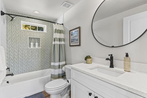 een badkamer met een wastafel, een toilet en een spiegel bij St Georges Getaway w firepit in Abbeyville