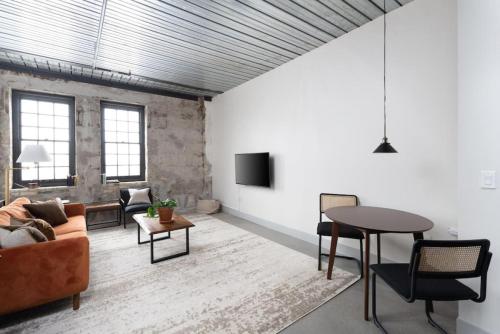 una sala de estar con un sofá y una mesa en Chic Double Queen Apt Walking Distance to Fiserv, en Milwaukee