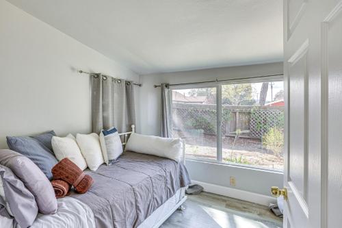 a bedroom with a bed with pillows and a window at 2 Mi to Dtwn Atascadero! Cozy Cottage with Yard in Atascadero