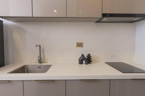 a kitchen with a sink and a counter top at Near Central Rama 9 with Balcony, Pool, Gym & 5m to MRT in Bangkok