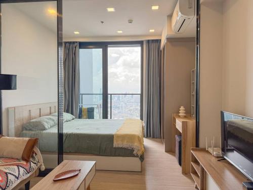a bedroom with a bed and a large window at Near Central Rama 9 with Balcony, Pool, Gym & 5m to MRT in Bangkok