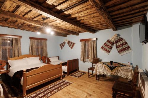 a bedroom with a bed and a desk and a television at Șura lu' Aurel in Gîrdani