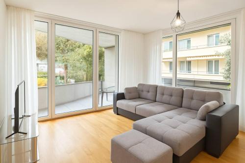 Montchoisi 1 bedroom Near Gare Ouchy Smart Lock في Ouchy: غرفة معيشة مع أريكة وتلفزيون