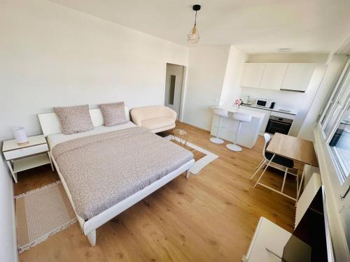 The Minimalist free Parking في Pully: غرفة بيضاء صغيرة بها سرير ومطبخ