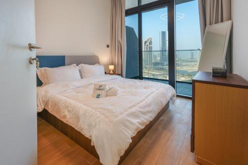 ein Bett mit zwei Büchern darauf in einem Zimmer mit Fenster in der Unterkunft 1 BR in Maryah Island with balcony in Abu Dhabi