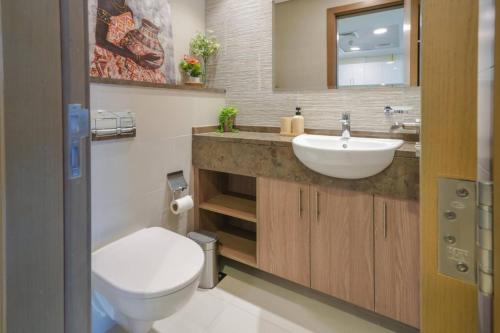 een badkamer met een wit toilet en een wastafel bij Park View Saadiyat Chic 1 BD in Mushayrib