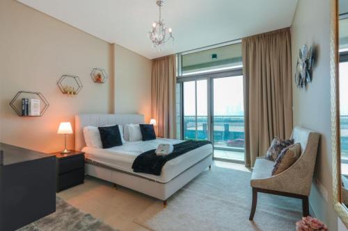 een slaapkamer met een bed en een groot raam bij Park View Saadiyat Chic 1 BD in Mushayrib