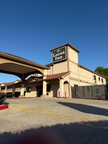 a building with a sign for a lounging inn at Lotus Inn in Houston