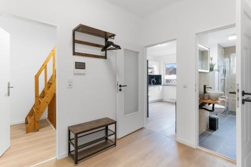 a living room with white walls and a staircase at Elite Weser Apartments in Bremen