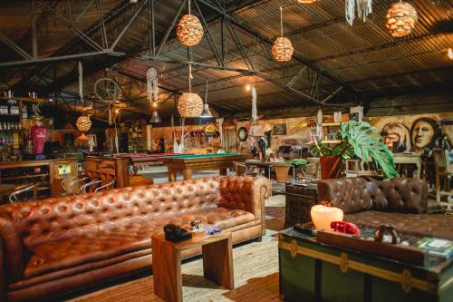 uma sala de estar com dois sofás de couro e uma mesa em Cerro Tusa Glamping em Titiribí