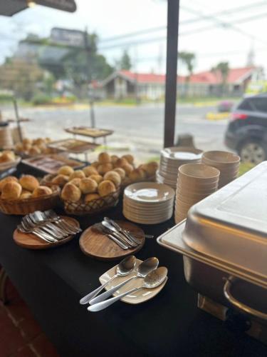 a table with plates and silver utensils on it at Hotel Boutique WenuPillan in Villarrica