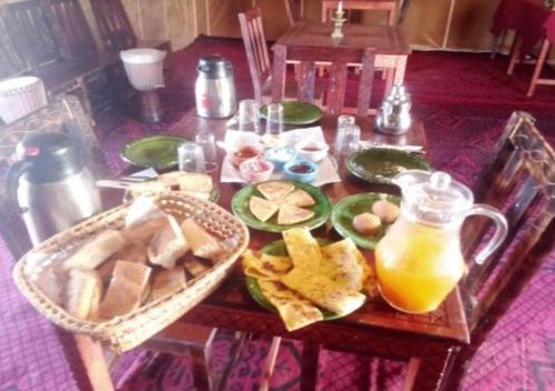 una mesa con un plato de comida y una jarra de jugo de naranja en berber sahara, en Zagora