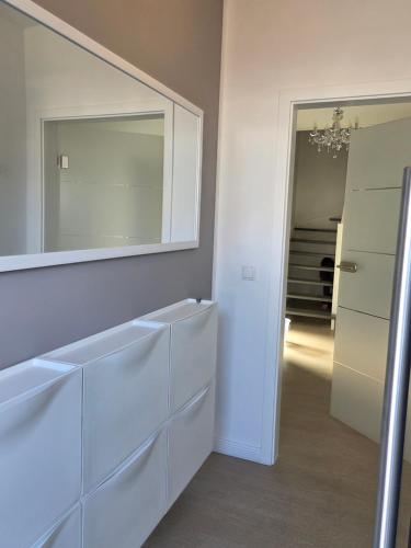 a bathroom with a large mirror and white dressers at Muttis Haus -Auf dem Felde in Ummern