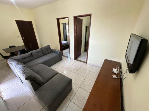 ein Wohnzimmer mit Couch und Flachbildfernseher in der Unterkunft Baratinho 2 quartos no ribeiro de abreu in Belo Horizonte