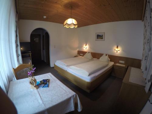 a bedroom with two beds and two tables in a room at Gästehaus Alpenland in Tux