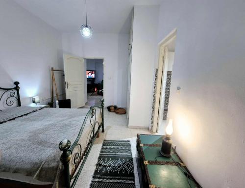 a bedroom with a large bed and a hallway at Maison hôte Dar Traki in Tozeur