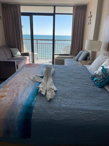 a stuffed animal laying on a bed in a bedroom at Ocean Front King Suit Myrtle Beach Heated Pools Landmark in Myrtle Beach