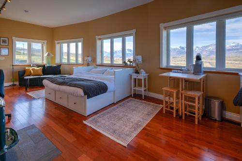 ein Schlafzimmer mit einem Bett und einer Couch und Fenstern in der Unterkunft Echos and Embers Waterton in Waterton Park