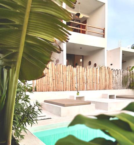 ein Haus mit Swimmingpool und Holzzaun in der Unterkunft Kasa Koh in Brisas de Zicatela