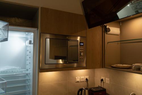 cocina con microondas en la pared en Penta Square Signature Hotel Apartments - DHA Phase 5 Lahore, en Lahore