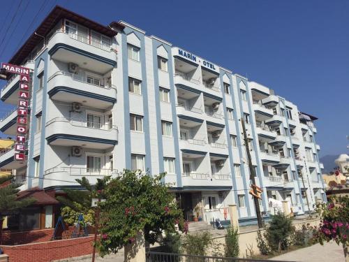 a large white building with balconies on a street at Marin Apart Arsuz in Arsuz