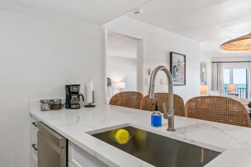 a kitchen with a sink and a counter top at Newly Reno Beachfront Escape I Steps to Beach in Clearwater Beach