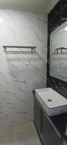 a bathroom with a white sink and a marble wall at LH Appart in Afourer