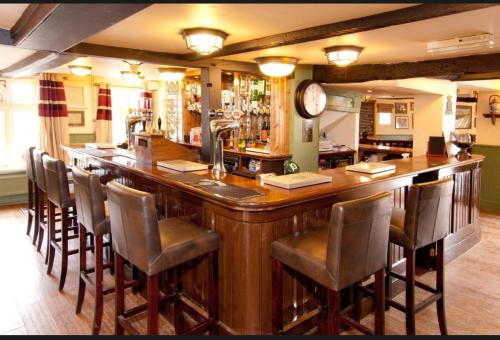 a large bar with chairs around it in a pub at george and horn in Kingsclere