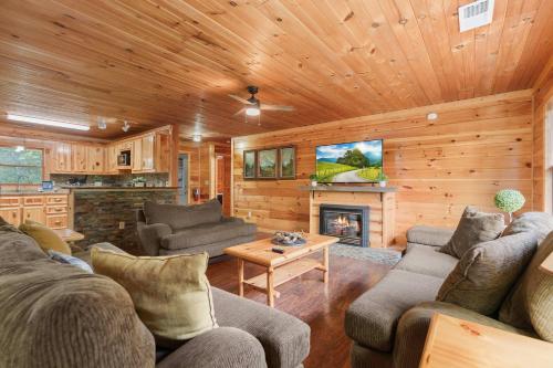 a living room with a couch and a fireplace at Cozy Cabin Sleeps 10 Hot Tub Pool Table Arcade in Shady Grove