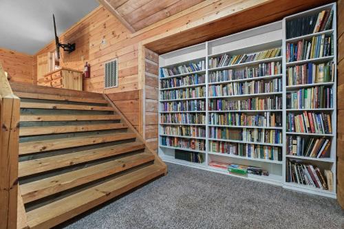 a library with wooden walls and shelves of books at Cozy Cabin Sleeps 10 Hot Tub Pool Table Arcade in Shady Grove