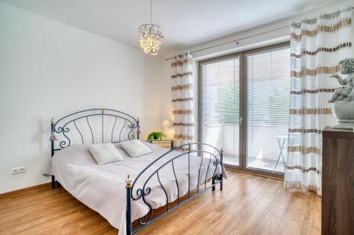 a bedroom with a bed and a large window at City Center Appartment with parking in Trnava