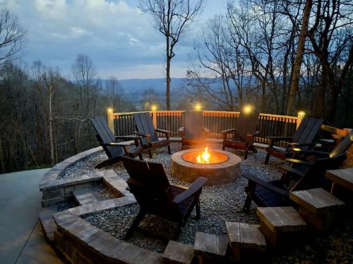 a patio with chairs and a fire pit on a deck at LUXE, Breathtaking Mountain Views, Hot Tub, Fire Pit, Fire Pit Table, Pool Table, 2 Living rooms, Universal EV Station in Hendersonville