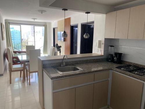 a kitchen with a sink and a table in it at Apartamento Excalibur 11B junto al mar in Gaira