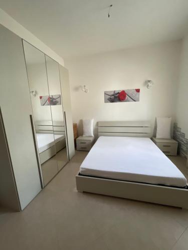 a white bedroom with a bed and a mirror at Casa Relax in Simaxis