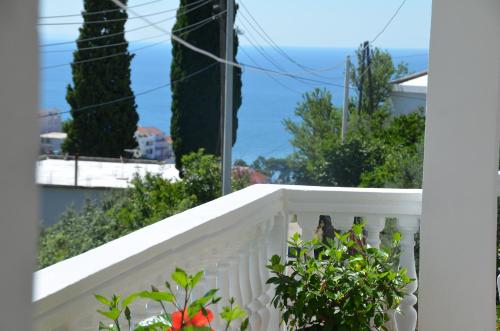 a bird sitting on the railing of a white fence at Apartment Dragovic in Ulcinj