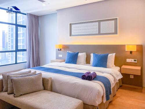 une chambre avec un grand lit avec des oreillers bleus dans l'établissement 188 Suites KLCC by VastHaven, à Kuala Lumpur