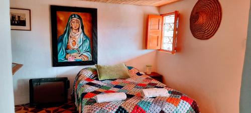 a room with a bed with a painting on the wall at La jinquita in La Unión