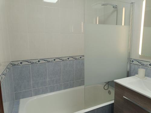 a bathroom with a bath tub and a sink at Dúplex JUNI in Bádames