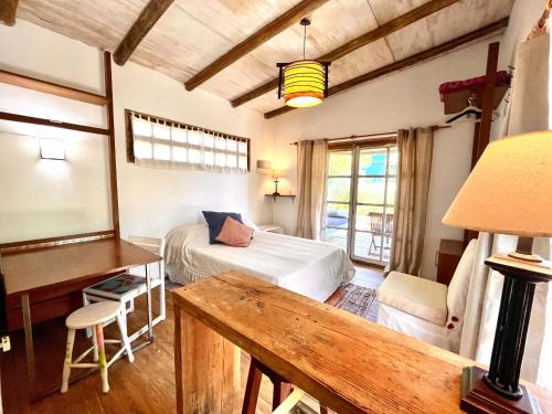 a bedroom with a bed and a table and a desk at Loft en La Juanita in José Ignacio