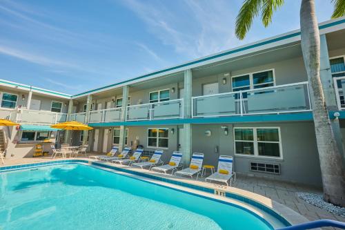 a swimming pool in front of a building at Camelot Beach Suites in Clearwater Beach