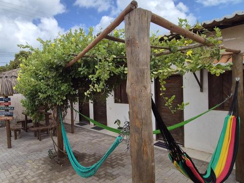 a couple of hammocks tied to a building at Pousada Coró in São Miguel do Gostoso