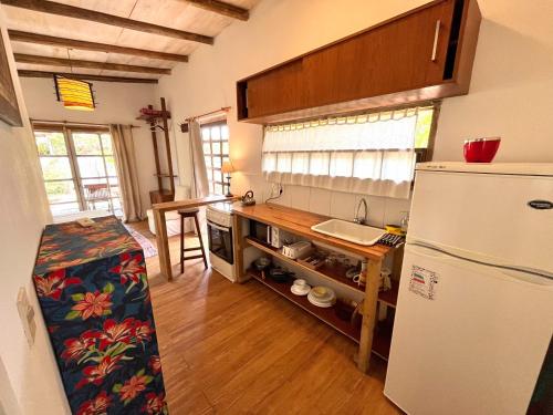 a kitchen with a white refrigerator and a wooden floor at Loft en La Juanita in José Ignacio