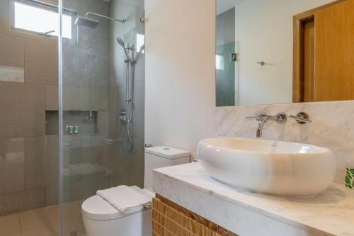 ein Badezimmer mit Waschbecken, Toilette und Dusche in der Unterkunft Luxury 3BR Pool Villa near Blue Tree - Bang Tao in Chalong 
