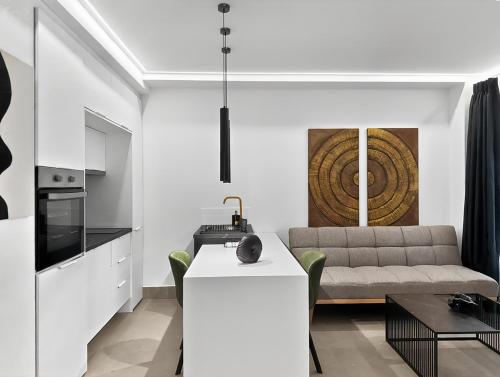 a kitchen and living room with a couch and a table at Ρομαντική απόδραση με Χαμάμ in Athens