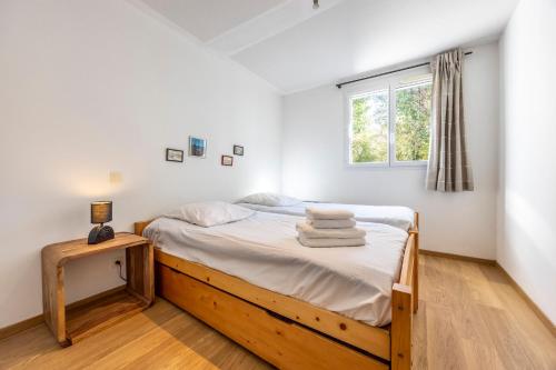 a bedroom with a bed with white sheets and a window at Le Bois de Mendi Alde in Cambo-les-Bains