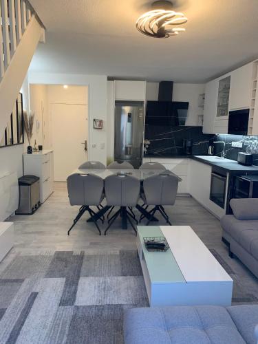 a living room with a table and a kitchen at L'Adresse Signature, Duplex d'Exception à Saumur in Saumur