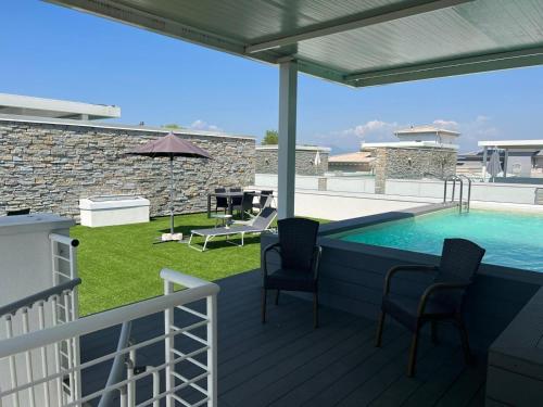 une piscine sur une terrasse avec des chaises et un patio dans l'établissement Elegante appartamento con piscina privata, à Peschiera del Garda