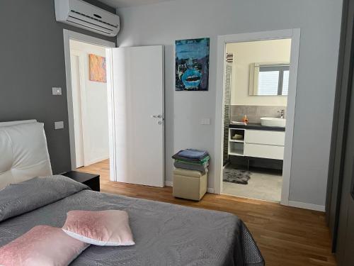 une chambre avec un lit et une salle de bain avec un lavabo dans l'établissement Elegante appartamento con piscina privata, à Peschiera del Garda