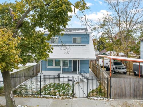 a blue house with a fence in front of it at Quiet Detroit 3BR | Near Downtown + WiFi in Detroit