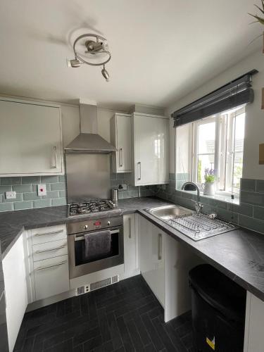 a kitchen with white cabinets and a sink at Flat in Filton Mod Rolls Royce gkn in Bristol